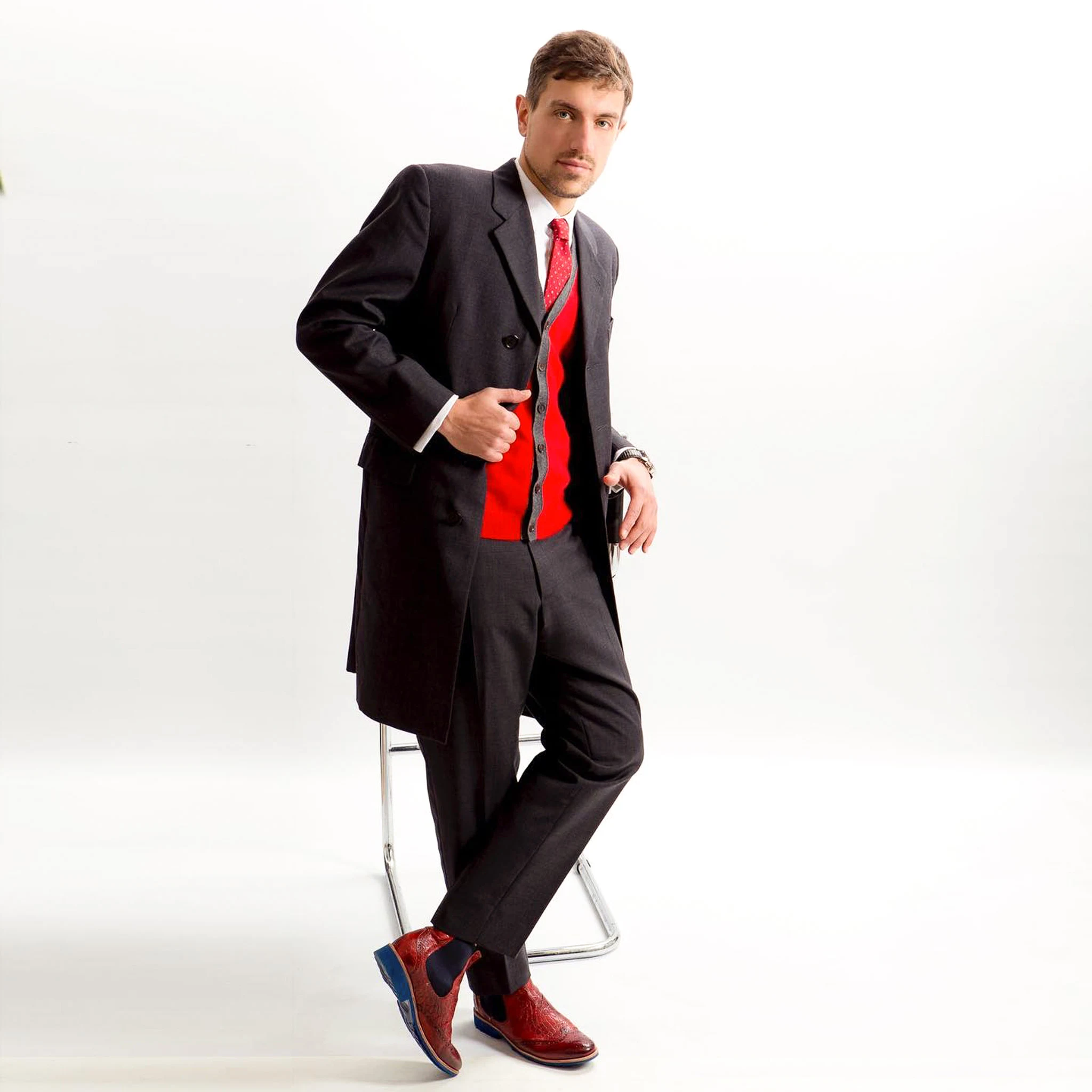 Herren-Outfit mit grauem Mantel, rotem Cardigan und Budapester Schuhen