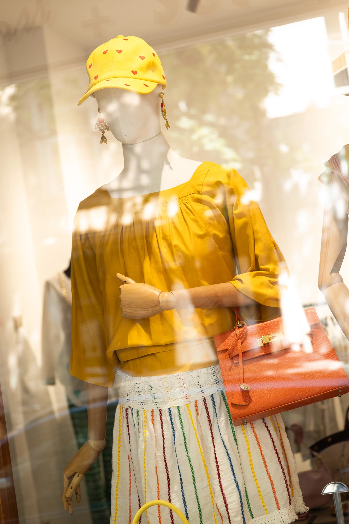 Schaufensterpuppe mit gelber Bluse und oranger Tasche bei Ladies First